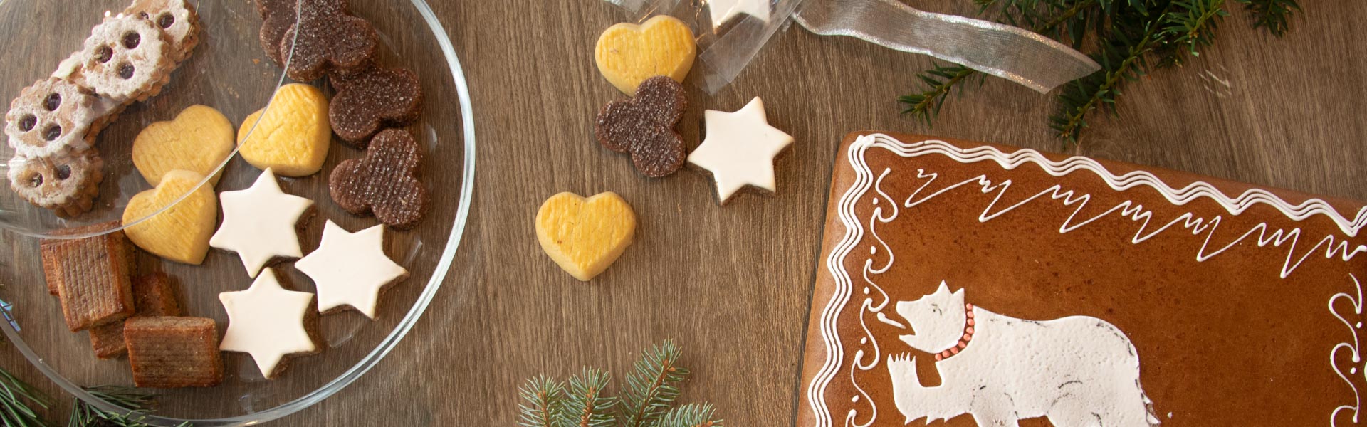 Weihnachtskonfekt und Lebkuchen liegen auf einem festlichen Tisch verteilt.