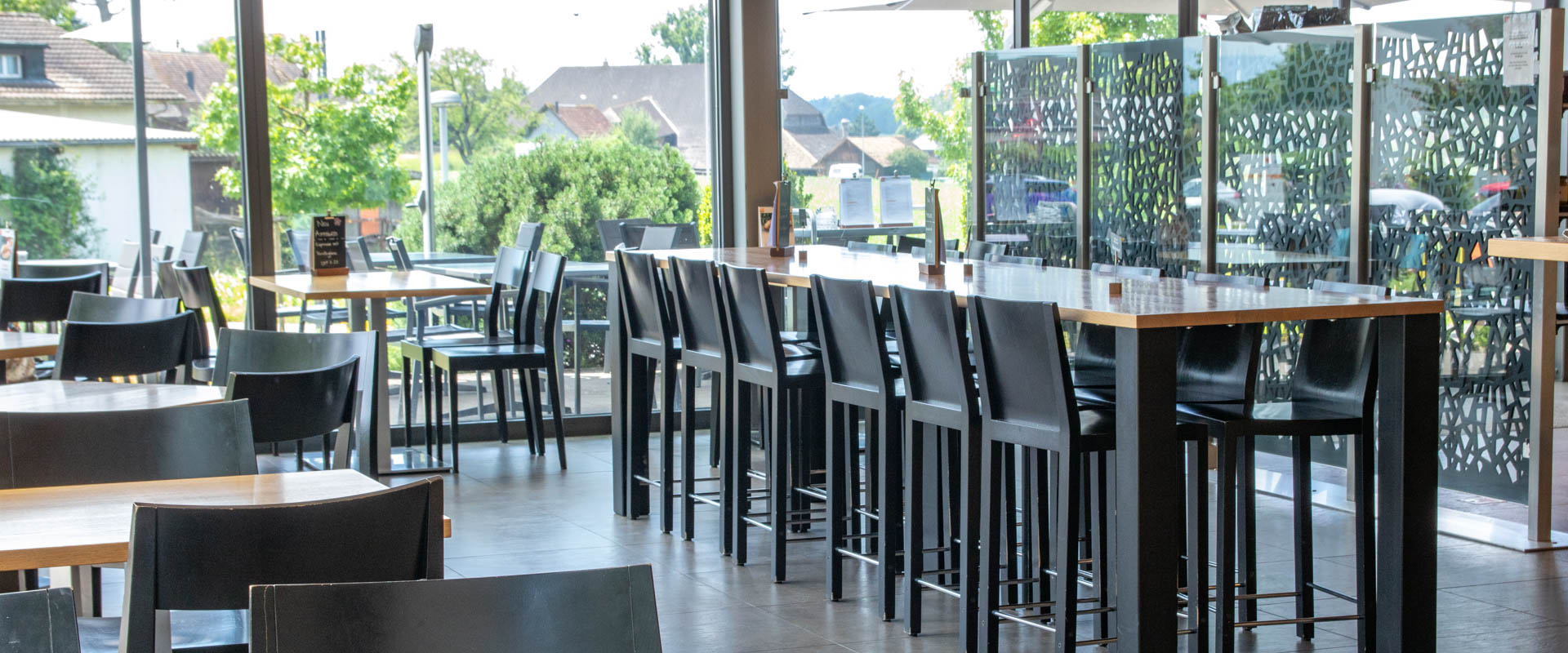 Café mit grossem Tisch in der Mitte in der Filiale Koppigen Aspi