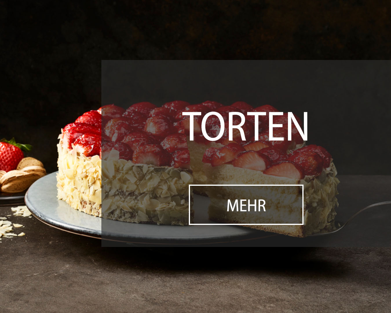 Fruchtorte garniert mit frischen Erdbeeren, ummantelt von Mandelsplittern wird angeschnitten.